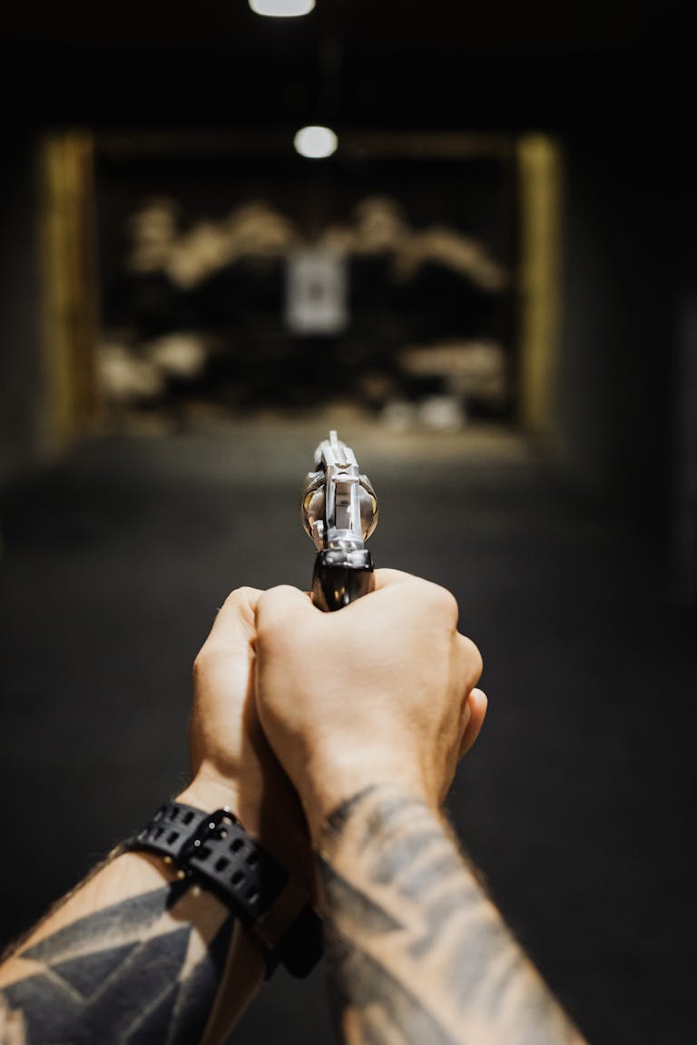 Hands of a Person Aiming a Handgun