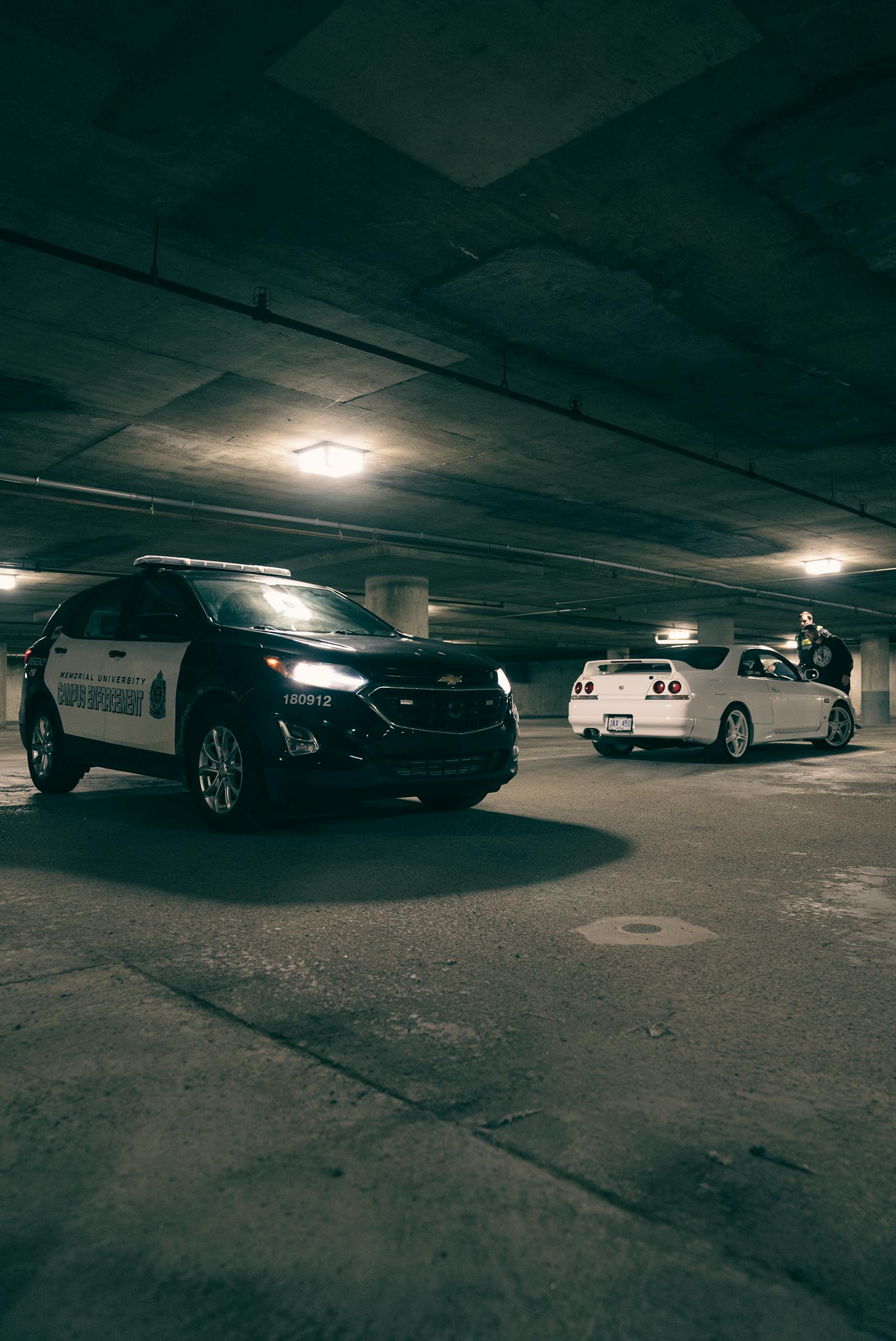 Two cars parked in a parking garage