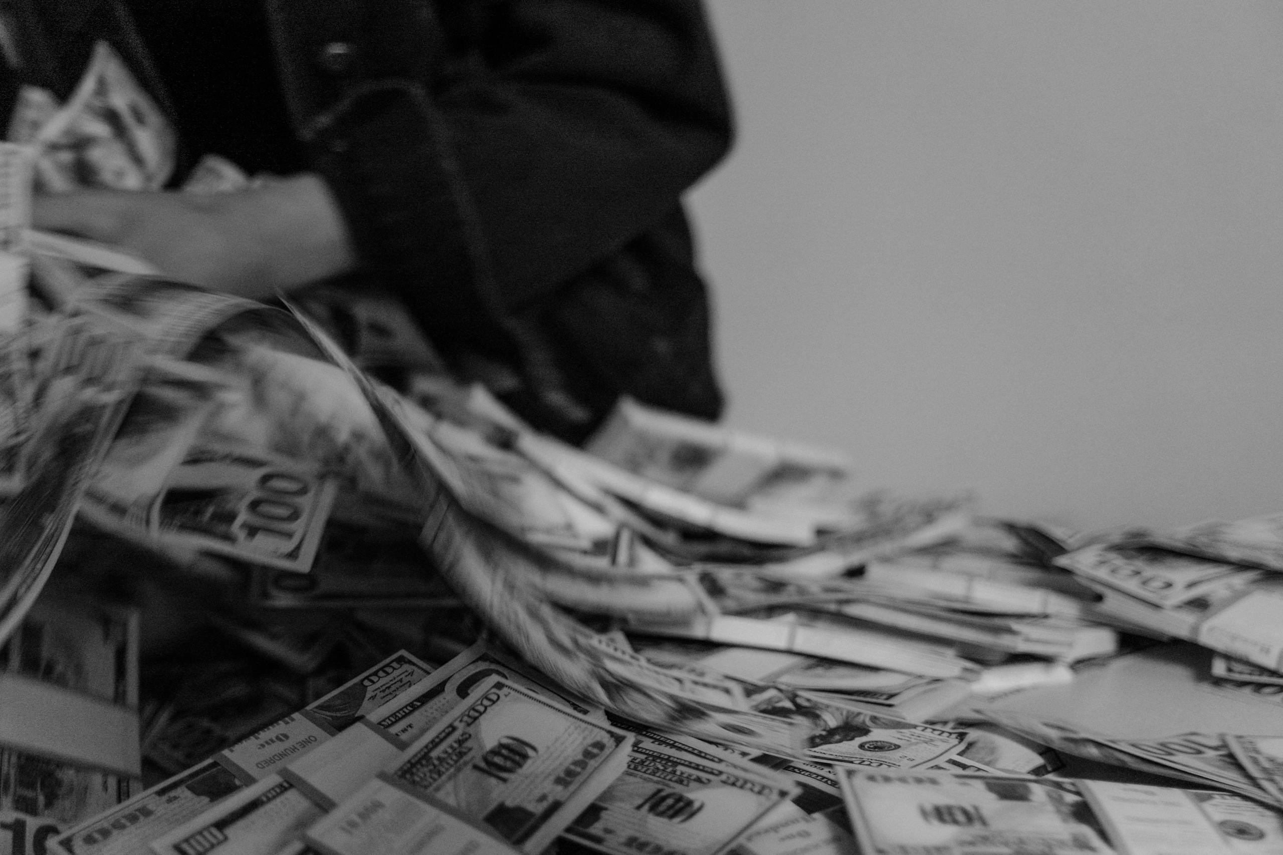 Grayscale Photo of Person Holding Stack of Us Dollar Bill