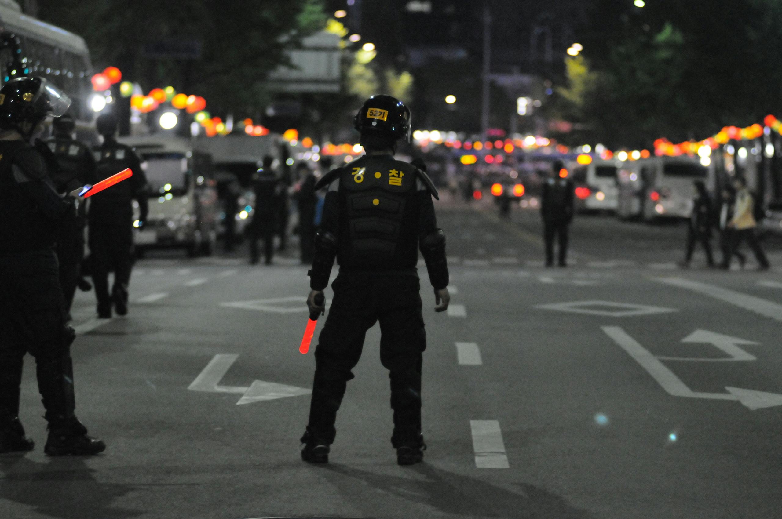 Police Standing on Gray Asphalt during Nighttime