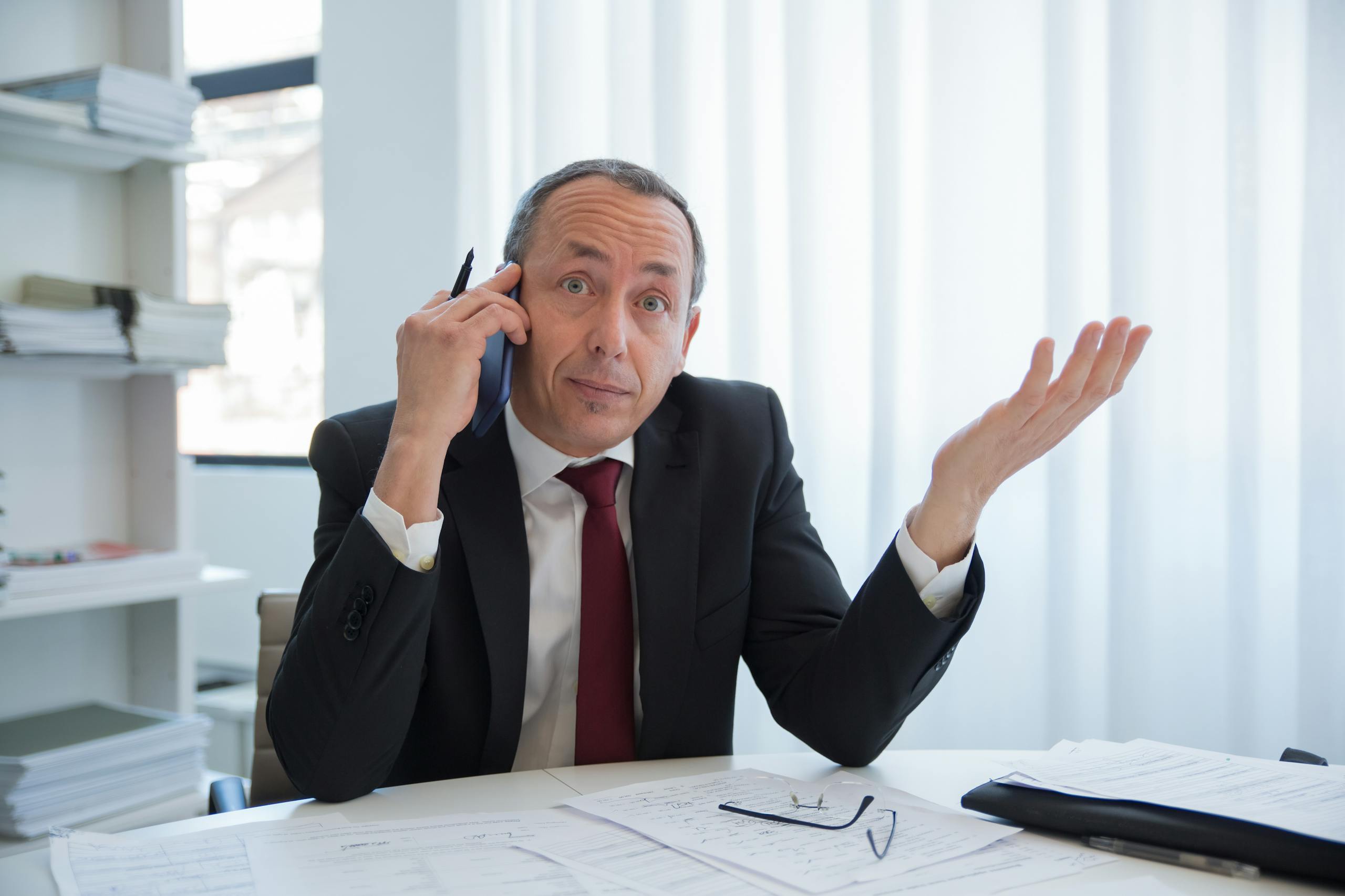 A Man in Black Suit Talking on the Phone