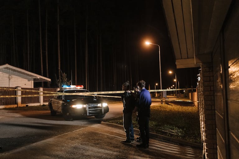 A Police Car Parked on the Road Between Houses