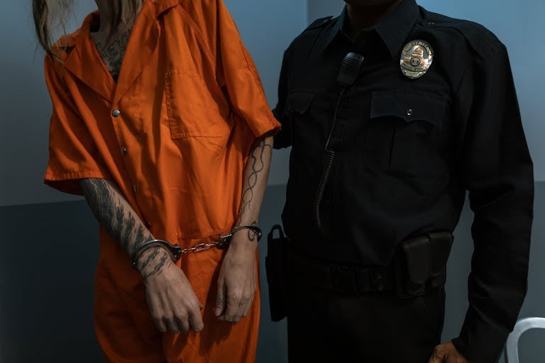 Man in Orange Jacket Standing Beside Man in Black Leather Jacket