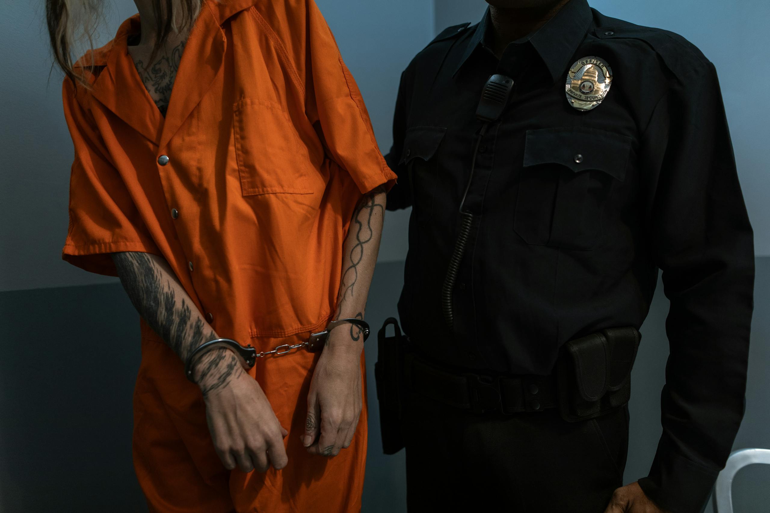 Man in Orange Jacket Standing Beside Man in Black Leather Jacket