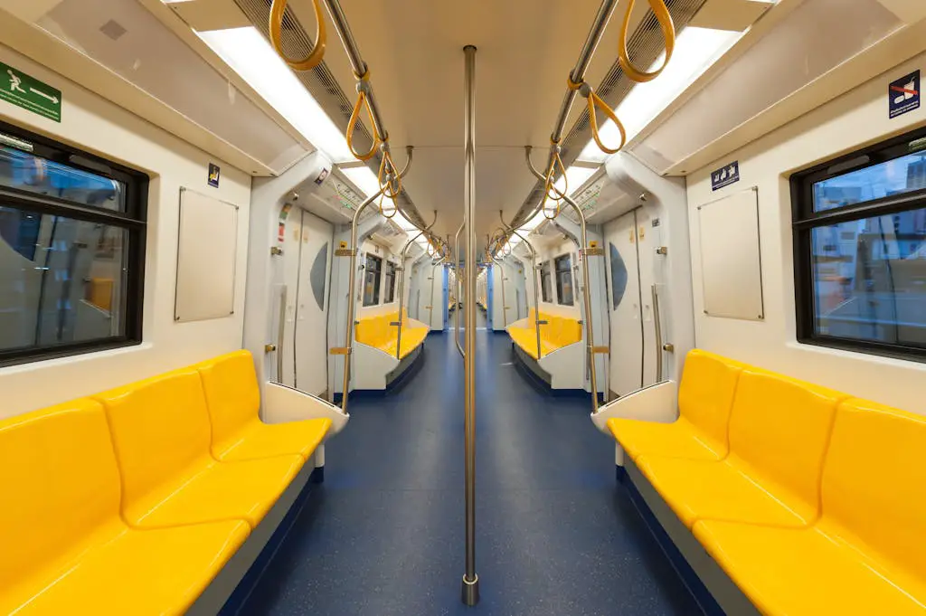 Interior of a modern subway car with bright yellow seats and clean design, emphasizing public transportation.