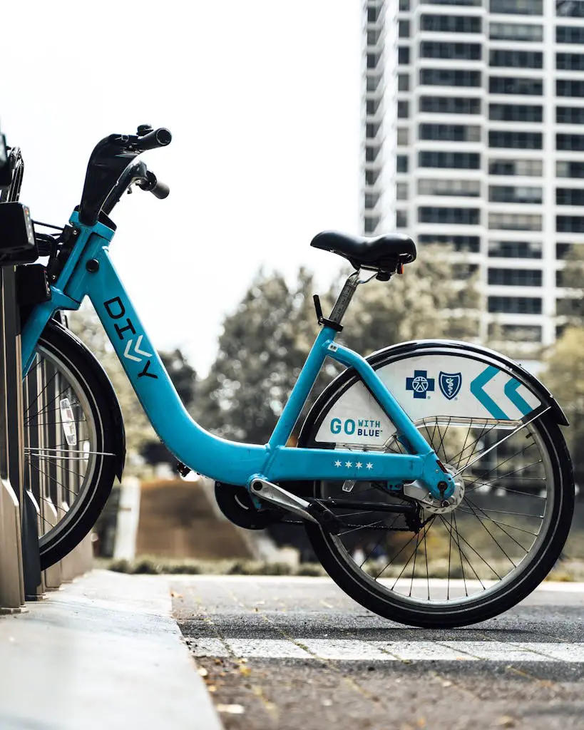 Vibrant blue Divvy bike parked at a docking station in an urban outdoor setting.